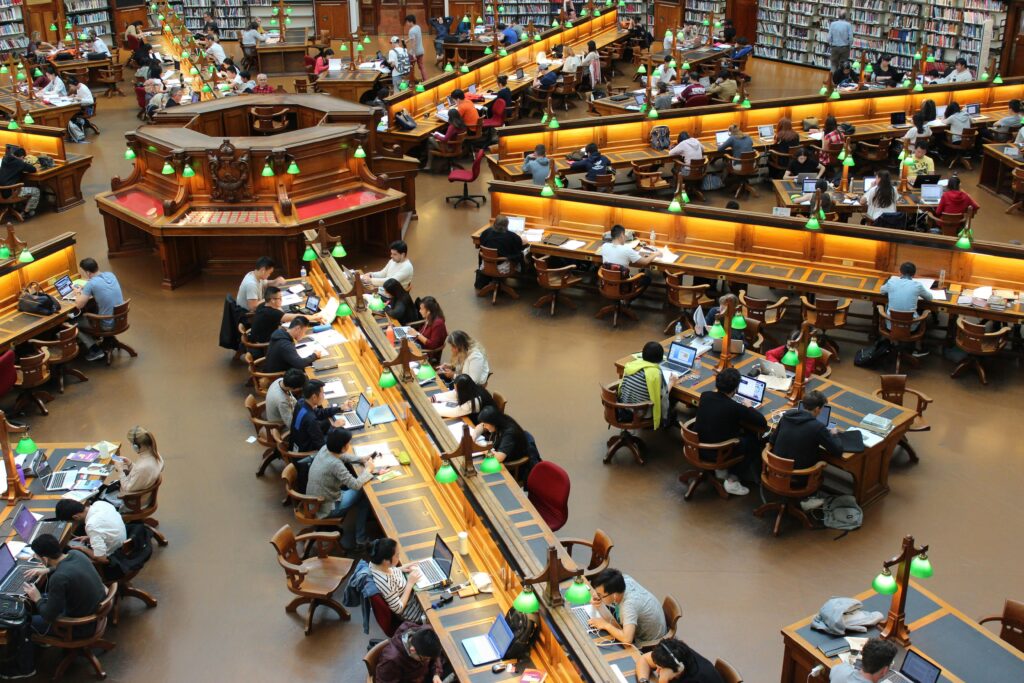 library la trobe study students 159775 159775 A lively university library scene with students studying diligently at wooden desks.
