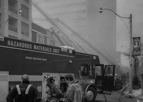 pexels photo 3122821 3122821 Black and white image of firefighters managing a city building fire with hoses and fire truck.